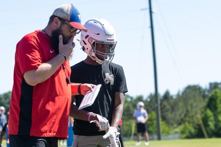 OCHS offensive coordinator Josh Austin talks with wide receiver Rico Howard during practice at Oglethorpe County High School in Lexington, Georgia. (Ethan Greene/The Oglethorpe Echo)