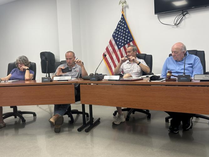 Arnoldsville City Council members Joyce Sniff (from left), Blake Arnold and Joel Kriner, and Mayor Danny Morcom (right) discuss water problems and other issues at its meeting on July 16. The city announced a mandatory restriction on outdoor water usage this month. (Jessie Isaacs/The Oglethorpe Echo)