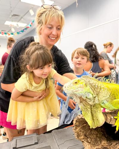 Brooke Shook shows her children, Sonny Shook (left) and Copeland Shook,  an iguana at The Oglethorpe County Library's reptile encounter on June 9. A total of 162 people were in attendance, which is a record for that event. (Submitted Photo)