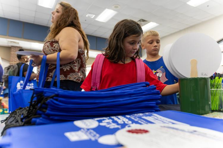 Londyn Colquitt takes a free pencil from one of the tables at Community Day on Saturday. Between 250-300 people attended the annual event. (Ethan Greene/The Oglethorpe Echo)