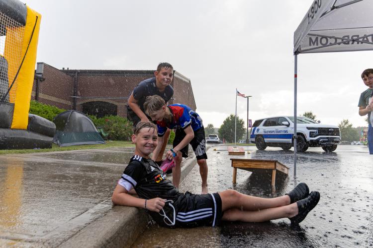 Grayson Hall, JD Mathe and Danny Archer play in the rain during Oglethorpe County Community Day hosted by Family Connection at Oglethorpe County Middle School in Lexington, Georgia, on Saturday, Aug. 8, 2026. (Ethan Greene/The Oglethorpe Echo)