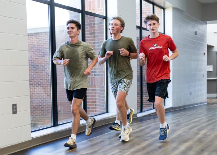 Luke Holbrooks (from left), Rex Allen and John Wanager practice with the cross country team inside OCHS on Monday. Many of the team’s practices this month have been indoors due to high temperatures and humidity. (Ethan Greene/The Oglethorpe Echo)