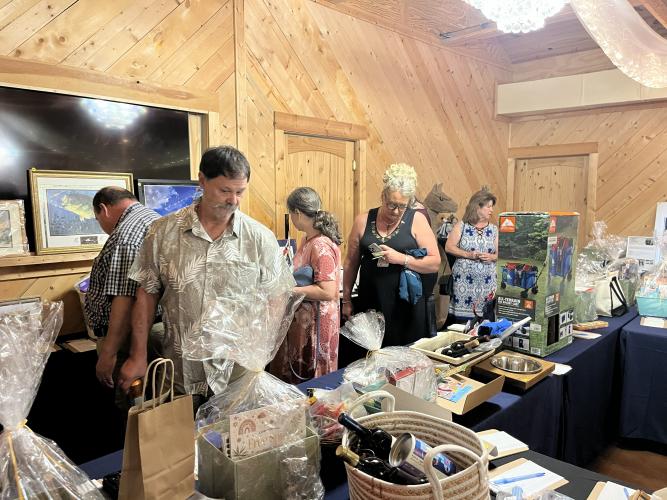 Attendees check out the silent auction at MOAS’ 11th annual Bark &amp; Wine at Countryside Manor in Winterville on Aug. 15. MOAS raised $50,000 at the event, doubling last year’s amount. (Sarah Nanos/The Oglethorpe Echo)