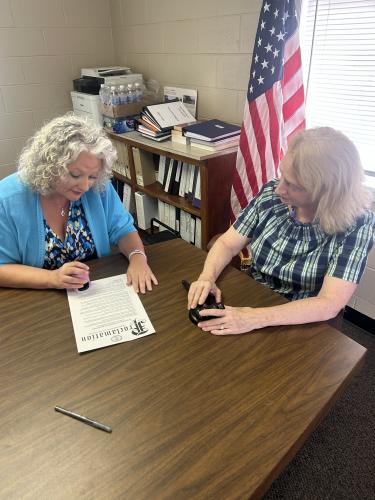 Kim Bradford, Lexington’s city clerk, stamps a paper proclaiming this week as Kim Bradford Appreciation Week. “The city is blessed to have her,” former Lexington Mayor Ronnie Boggs said. (Jessie Isaacs/The Oglethorpe Echo)