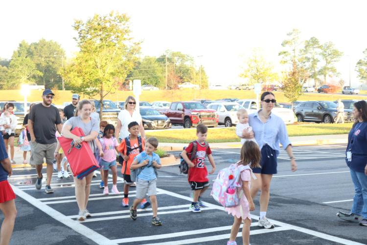 Parents walk their children into Oglethorpe County Elementary School on the first day of school last Friday morning. Principal Katie Baldwin said OCES is working through issues with the morning drop off and afternoon pick up. (Ellie English/The Oglethorpe Echo)