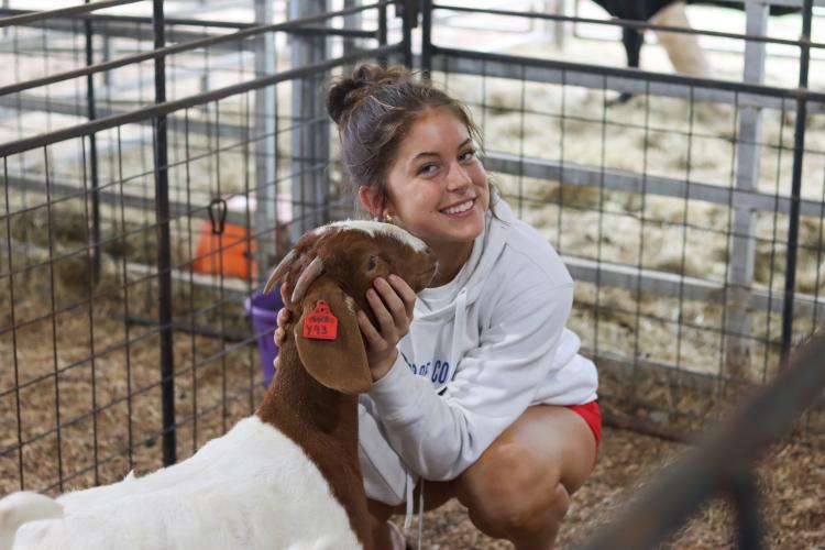 Naomi McPeake, 15, smiles with one of her show goats, Sexy Red, at her family’s farm in Crawford last month. She is a key starter on Oglethorpe County’s state volleyball team and has won several awards with her goats. (SYDNEY JARRARD/THE OGLETHORPE ECHO)
