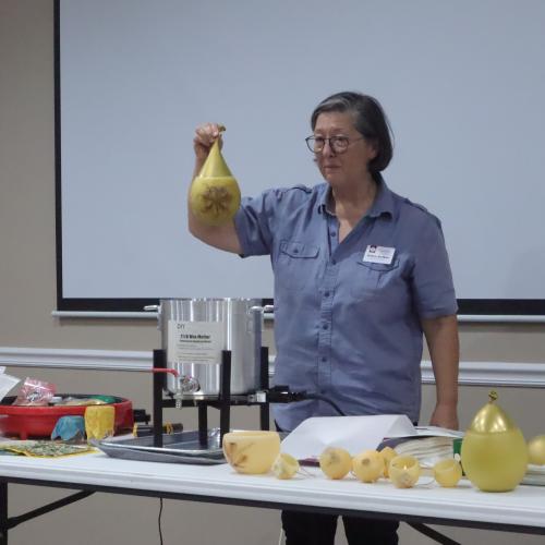 Deb DeWitt holds up a filled water balloon that she dipped in beeswax at a meeting of the Oglethorpe County Bee Club on Sept. 21. She showed the members how to slowly dip the balloon in and out of the wax to create a beeswax luminary. (Photo/Zaire Rushing-Simpson).