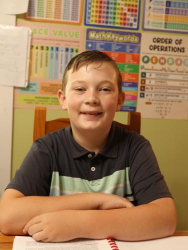 Josiah Haley, 11, is homeschooled by his mother throughout the week. Corrine teaches his lessons at the kitchen table, where they are surrounded by education posters that cover the walls. (Sophia Bobo/The Oglethorpe Echo).
