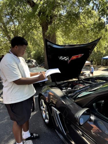 A judge writes notes about a 2010 Chevrolet Corvette Grand Sport convertible at the Firefly Cruise In on Sunday. Judges awarded 10 Best of Cruise plaques and one Best of Chamber plaque. (Maura Potvin/The Oglethorpe Echo)