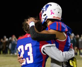 Brady Allgood (23), a junior, and Henry Johnson (18), a senior, hug after Oglethorpe County's season-ending loss to Westside-Augusta. Oglethorpe County honored the seniors on the fall sports teams, cheerleaders and band, before and after the game. (Photo/Sarah White)