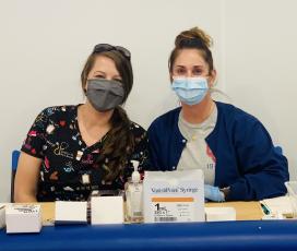 Erin Bunch (left) and Kristina Turner wear their masks while they work at a vaccine clinic. (Submitted Photo)