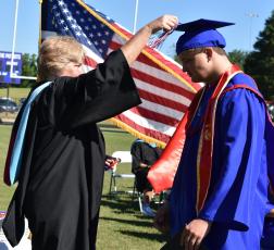 Oglethorpe County School System Superintendent Beverley Levine turns Alexander Neesmith’s tassel at the Oglethorpe County High School graduation ceremony last Saturday. Neesmith, who wore a red stole to honor the U.S. Marines, was one of 133 graduates in the OCHS Class of 2022. (Photo/Sarah Evans)