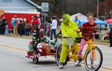 The Grinch rides in tandem with Christmas cheer, throwing candy  at those lining the street at the Maxeys Christmas Parade.