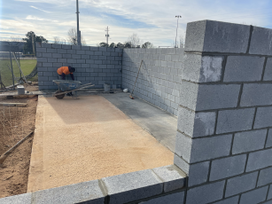 A worker puts the finishing touch on the concrete blocks that make up the walls of the newly expanded home dugout at the Oglethorpe County baseball field. (Submitted Photo)