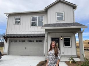 Kassie Hodges, a real estate agent with Keller Williams Realty, stands in front of a model home at The Pines at Grove Creek in Crawford. This home isn’t in the 29-lot development, but homes in The Pines at Grove Creek will be built using this plan. (Margaux Binder/The Oglethorpe Echo)