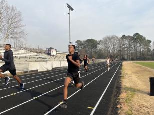 Oglethorpe County boys track coach Maurice Freeman runs with freshman Nicah Pass during a recent practice. Freeman is an OCHS grad who ran at Georgia before returning to Oglethorpe County. (Photo/HankTatum)