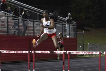 Kenzie Henderson soars over a hurdle on her way to finishing third. WOODY LOFTON/THE OGLETHORPE ECHOin the 300M hurdles at the Titan Invitational last week. She won the high jump and was on the 4x100 relay team that finished fourth.