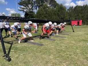 The offensive line works on drills to fill gaps and stay low during spring practice. (Hank Tatum/The Oglethorpe Echo)