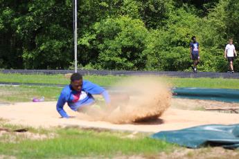Sophomore Kemauri Brown practices the long jump at Oglethorpe County High School track and field practice on April 23. (Samuel Higgs/The Oglethorpe Echo)