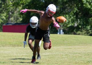 Defensive back Nicah Pass reaches for the ball during football practice on May 15. Pass, a senior, plays alongside his brother, Zion, a sophomore. (Ethan Greene/The Oglethorpe Echo)