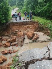 Several people take a look at the damage to Emerald Green Drive caused by heavy rains in the county the past week. About 30 people were stranded on one side of the dead-end road. (Photo/Submitted)