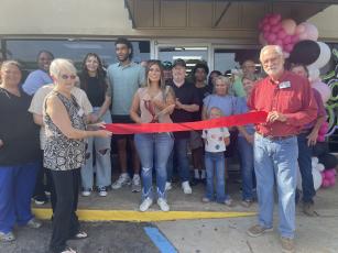 Surrounded by friends, family and local officials, Stephanie Mattox-Nation gets ready to cut the ribbon at the grand opening of The Local Spot, a new restaurant in Crawford, on Friday morning. The business, located at 1185 Athens Road, has a few unique appetizer options, such as Philly cheesesteak egg rolls and dill pickle and cream cheese bombs. (Lexie Shadix/The Oglethorpe Echo)