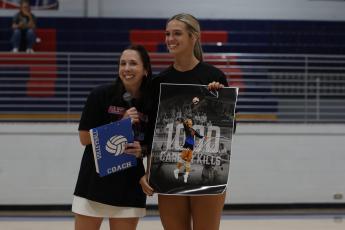 Oglethorpe County volleyball coach Brianne Harrison presents Leanna Newton with a poster signifying she’s surpassed 1,000 career kills on Tuesday night. Newton, a junior, leads the Patriots with 322 kills this season. (Wesley Webb/The Oglethorpe Echo)