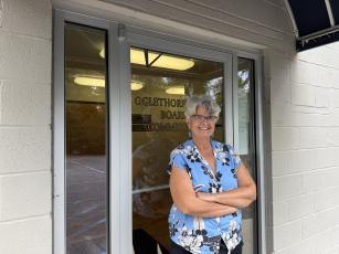 Hill stands and poses in front of the entrance to the zoning board meeting room on Oct. 2, 2026. She is retiring at the end of the year after ten years of service in Oglethorpe County. (Photo/Ren Grimsley)