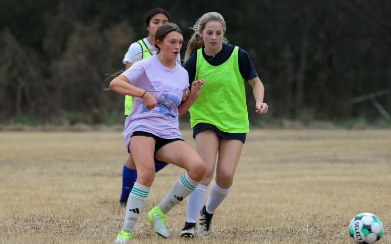 Focused and determined Meadow Nimmons (left) and Aidan Hill (right) battle for possession. The two display high energy as they both work to control the ball in the open field. (Addison Simmons/The Oglethorpe Echo)