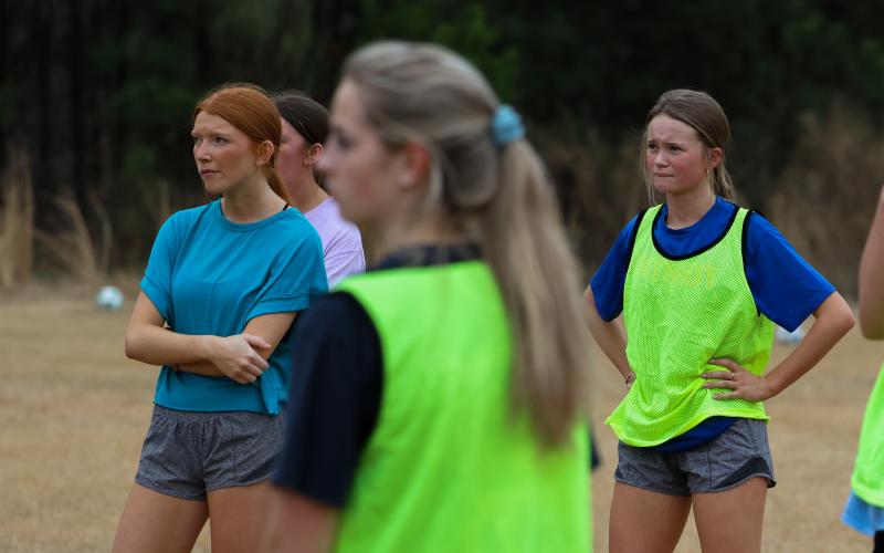 Mylee Nimmons (left) and Reese Campbell (right) as they hear head coach Madison for the next drill the team will run. The teams focus in on constantly improving the little things. (Addison Simmons/The Oglethorpe Echo)