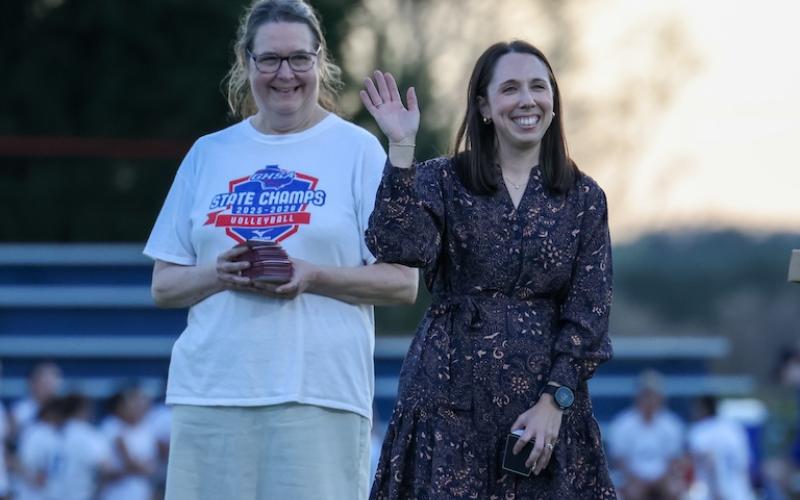 OCHS volleyball coach Brianne Harrison and assistant coach Toni Walser-Childs enjoy the moment during the ring ceremony between soccer games on Tuesday. They led the volleyball team to a 32-8 record and the Class A state championship last fall. (Sydney Shankman/The Oglethorpe Echo)