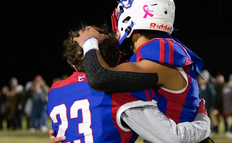 Brady Allgood (23), a junior, and Henry Johnson (18), a senior, hug after Oglethorpe County's season-ending loss to Westside-Augusta. Oglethorpe County honored the seniors on the fall sports teams, cheerleaders and band, before and after the game. (Photo/Sarah White)