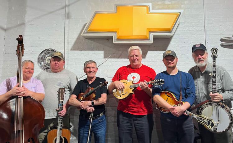 Deirdre Smith, John Smith, Robert Hauth, Dennis Helmreich, Robert Smith and Mike Harrison pose at G Brand BBQ  in Crawford. The bluegrass group hosts “jam sessions” at the restaurant every Thursday night. (Shannon Moran/Oglethorpe Echo)