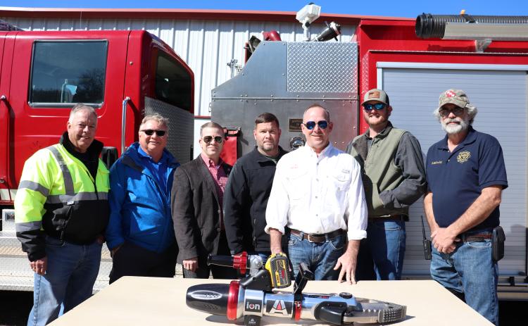 (Eloise Mcnair/Oglethorpe Echo) Devil’s Pond assistant fire chief Rocky Miller (from left), Rick Skoglund,  Commissioner Tracy Norman, Frank Moore, Jay Filipiak, T.J. Lowe and  Robby McCurley pose in front of the JAWS Combi Tool they helped  purchase for the Devil’s Pond Fire Department.