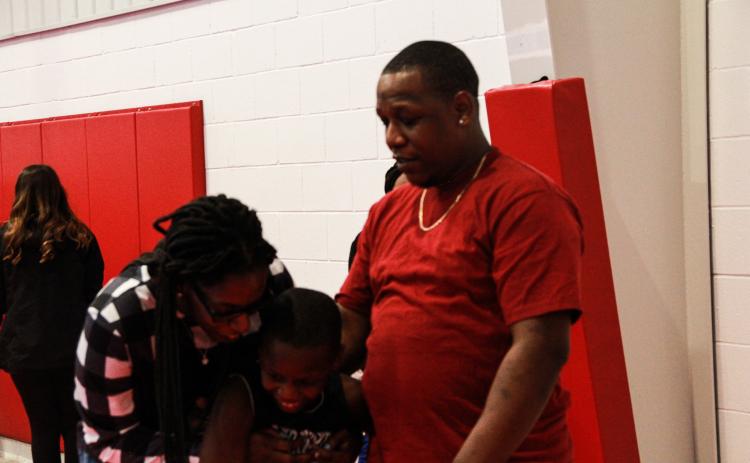 Reggie Mattox, who scored 20 of his team’s 24 points, and his family hug after the Oglethorpe Recreation Department Championship game