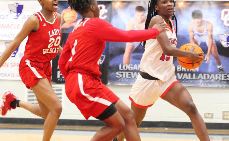Oglethorpe County’s Kenzie Henderson races past two Laney defenders on her way to the basket on Tuesday night. Henderson scored 21 points in the loss. (Ralph Maxwell/Submitted Photo)