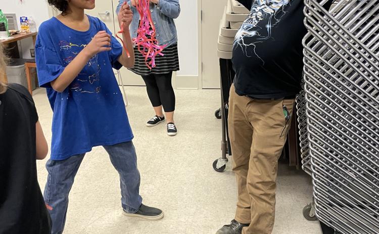 Sidney Wightman holds a  pinata for Marty Barclay at the  Oglethorpe County Library’s  Teen Anti-Valentine’s Day event. (Yana Obiekwe/Oglethorpe Echo)