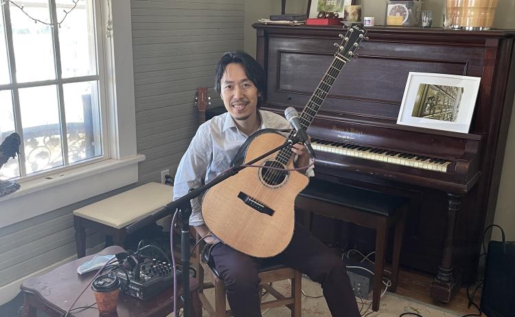 Hiroya Tsukamoto performs with his guitar. Originally from Kyoto,  Japan, his performance is a fusion of jazz, folk and world music. (Sabrina Laster/The Oglethorpe Echo)