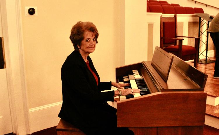Nina Hayes poses with the organ that she played every Sunday for 59 years at the Salem Baptist Church. Eloise McNair/The Oglethorpe Echo