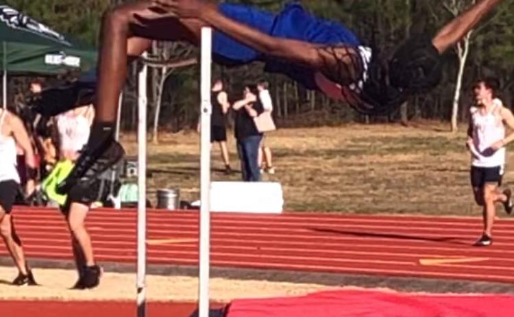Kenzie Henderson leaps over the bar to set a school and region record of 5 feet, 6 inches in the high jump at the season-opening meet on March 3. (Submitted Photo)
