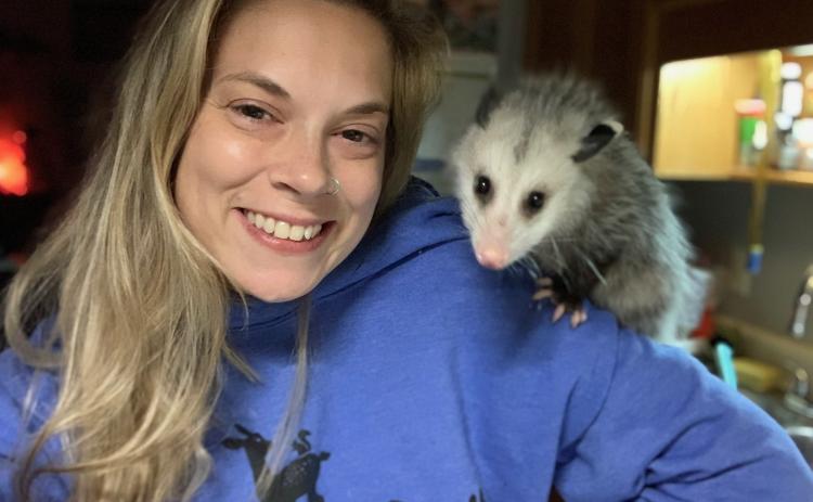 Nikki Hughes, founder of Camp Critter Wildlife Rescue, receives a visit from Persephone the Possum. Persephone  was a non-release case and now is the ambassador possum at Chattahoochee Nature Center in Roswell. (Submitted Photo)