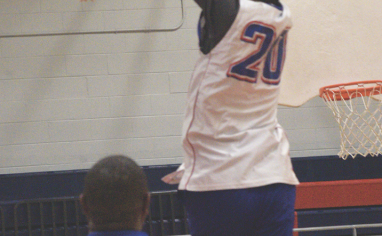 Coach Maurice Freeman shows off his vertical by dunking in the community basketball fundraiser games at OCHS on March 24. (Ralph Maxwell/Submitted Photo)