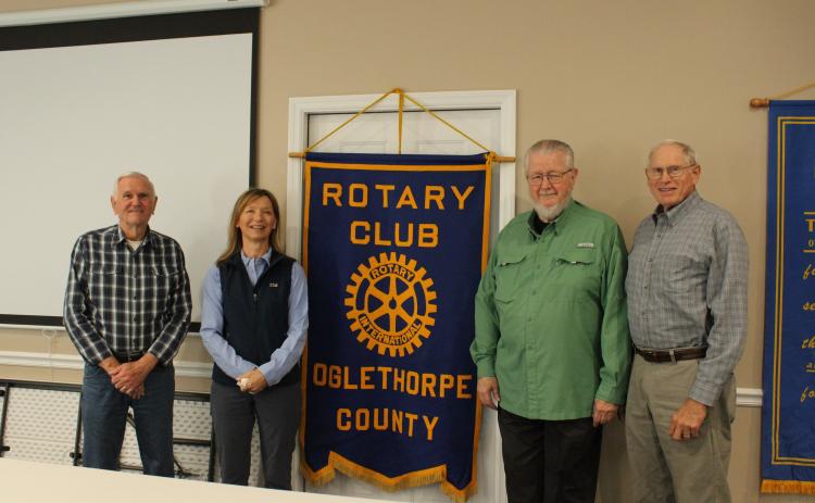 Oglethorpe County Rotary Club founding charter members pose with current president Susan Sharp in front of the chapter’s flag. Roger Neesmith (from left), Sharp, John Stephens and Bill Cabaniss are pictured. (ELOISE MCNAIR/THE OGLETHORPE ECHO