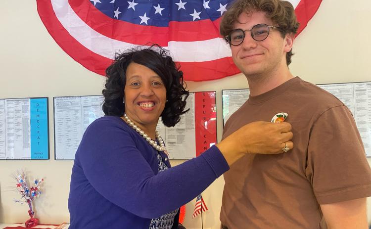 Clay Reece, 18, a senior at Oglethorpe County High School, receives his sticker from election supervisor Marilyn Huff-Waller on Tuesday after voting for the first time. (Photo/Dink NeSmith)