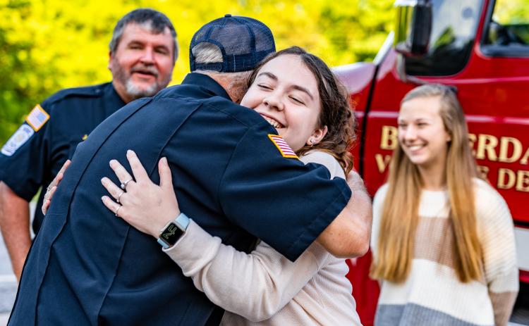 OCHS senior Elisse Griffiths hugs Carl Young, the Chief of Oglethorpe County Fire and Rescue after the Beaverdam Volunteer Fire Department gave $2,000 to help fund HOSA’s trip to the international competition. (Photo/Jack Casey)
