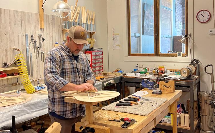 Owner Jason Booth works on a guitar for a customer. Booth says it takes around 30 hours to build a guitar from start to finish. (Photo/Colt Yeargin)