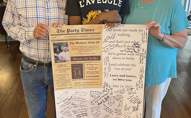 More than 260 people flew or drove to Perry to help celebrate Larry and Janice Walker’s 80th birthdays. One of Larry Walker’s biggest fans is Perry’s Deborah Roberts, a UGA grad and journalist for ABC News, who traveled from New York City. Roberts stands between the Walkers, holding a commemorative birthday poster. (Photo/Dink NeSmith)