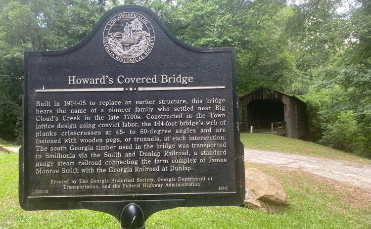 The historical marker tells the story of Howard’s Covered Bridge, which has been painted with graffiti. (Photo/Dink NeSmith)