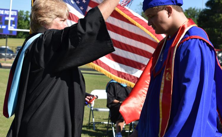 Oglethorpe County School System Superintendent Beverley Levine turns Alexander Neesmith’s tassel at the Oglethorpe County High School graduation ceremony last Saturday. Neesmith, who wore a red stole to honor the U.S. Marines, was one of 133 graduates in the OCHS Class of 2022. (Photo/Sarah Evans)