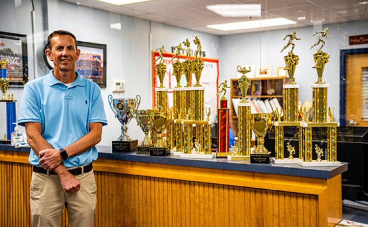 Assistant principal and assistant athletic director William Sampson displays the state and region championship trophies won by OCHS athletic teams this year. (Photo/Jack Casey)